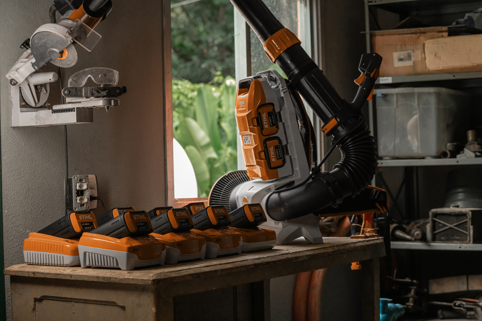 Das kabellose Laubblasgerät BGA 300 mit AP-System befindet sich in einer Werkstatt neben den Ladegeräten für den Akku AP 300 S140454