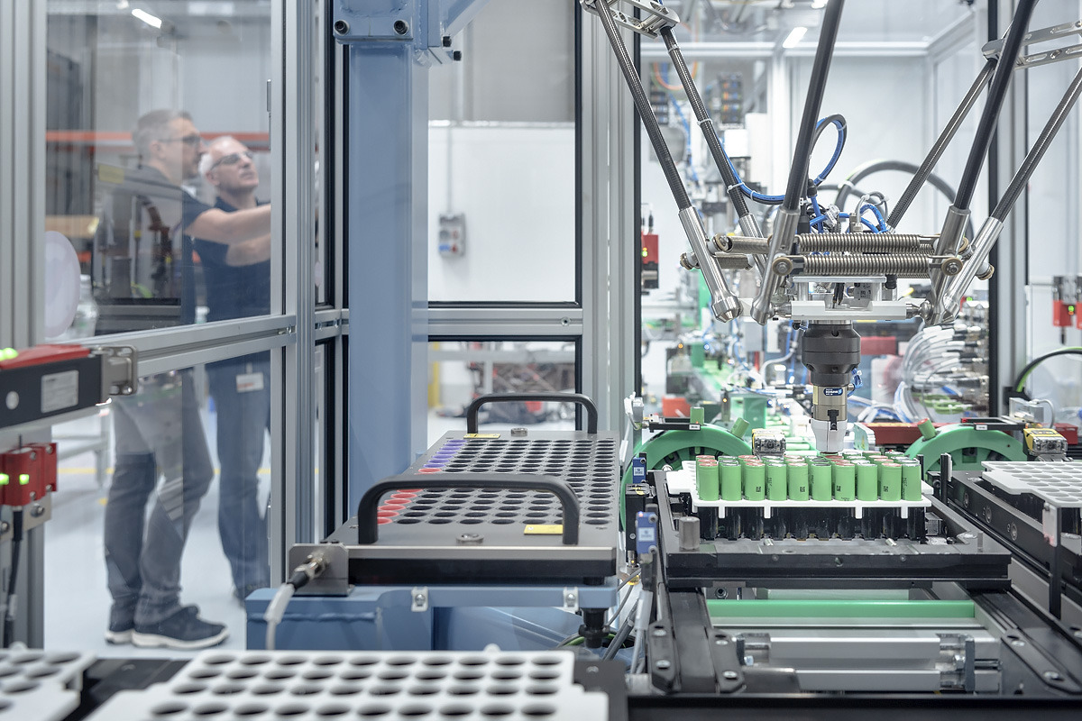 Entwickler stehen vor einer Akkufertigungsanlage