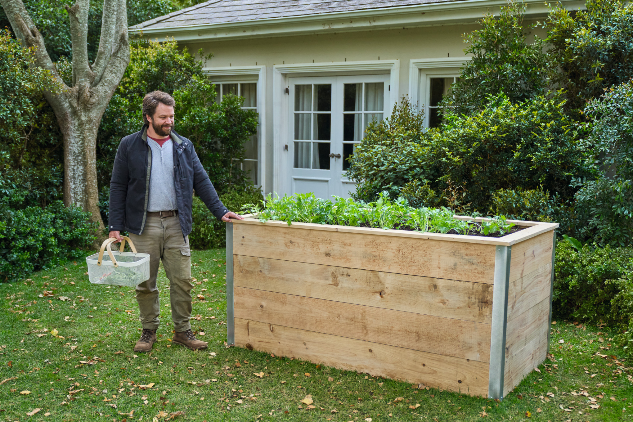 EIn Mann steht am Hochbeet