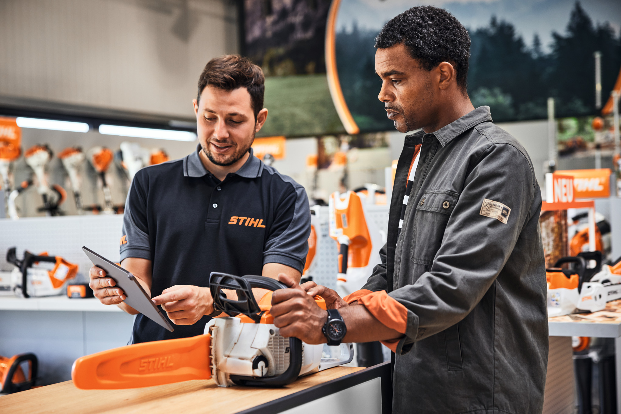 Ein STIHL Fachhändler berät ein Kundin beim Kauf einer STIHL Kettensäge