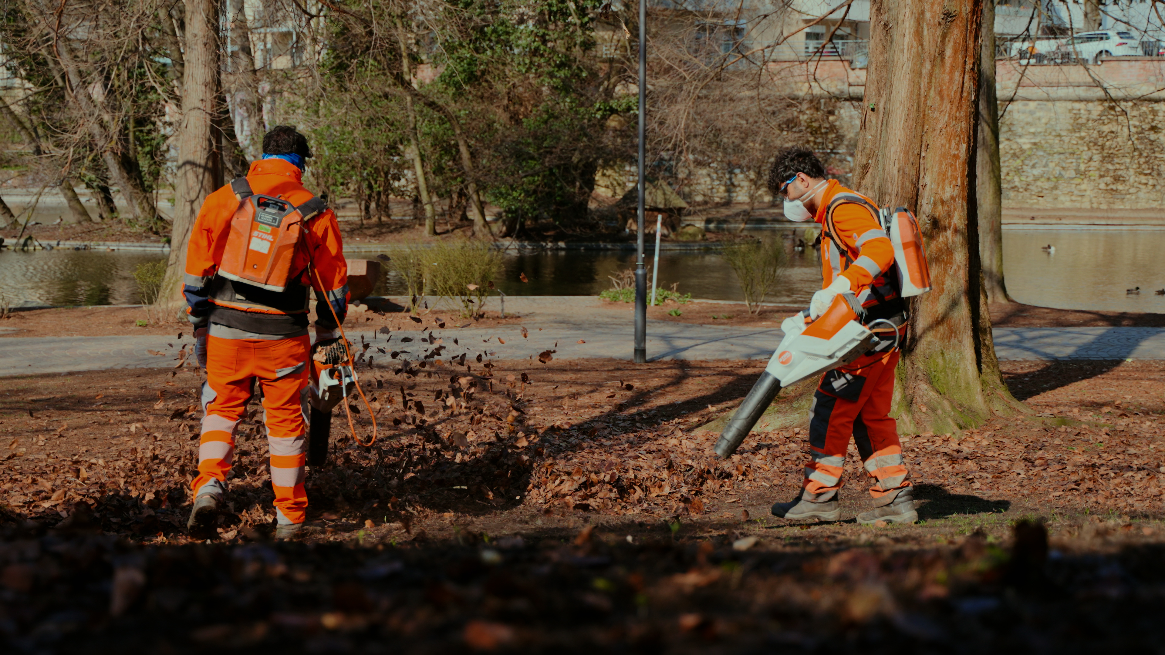 Zwei Profis von der FFR arbeiten mit STIHL AP Blasgeräten und rückentragbaren Akkus im Laub