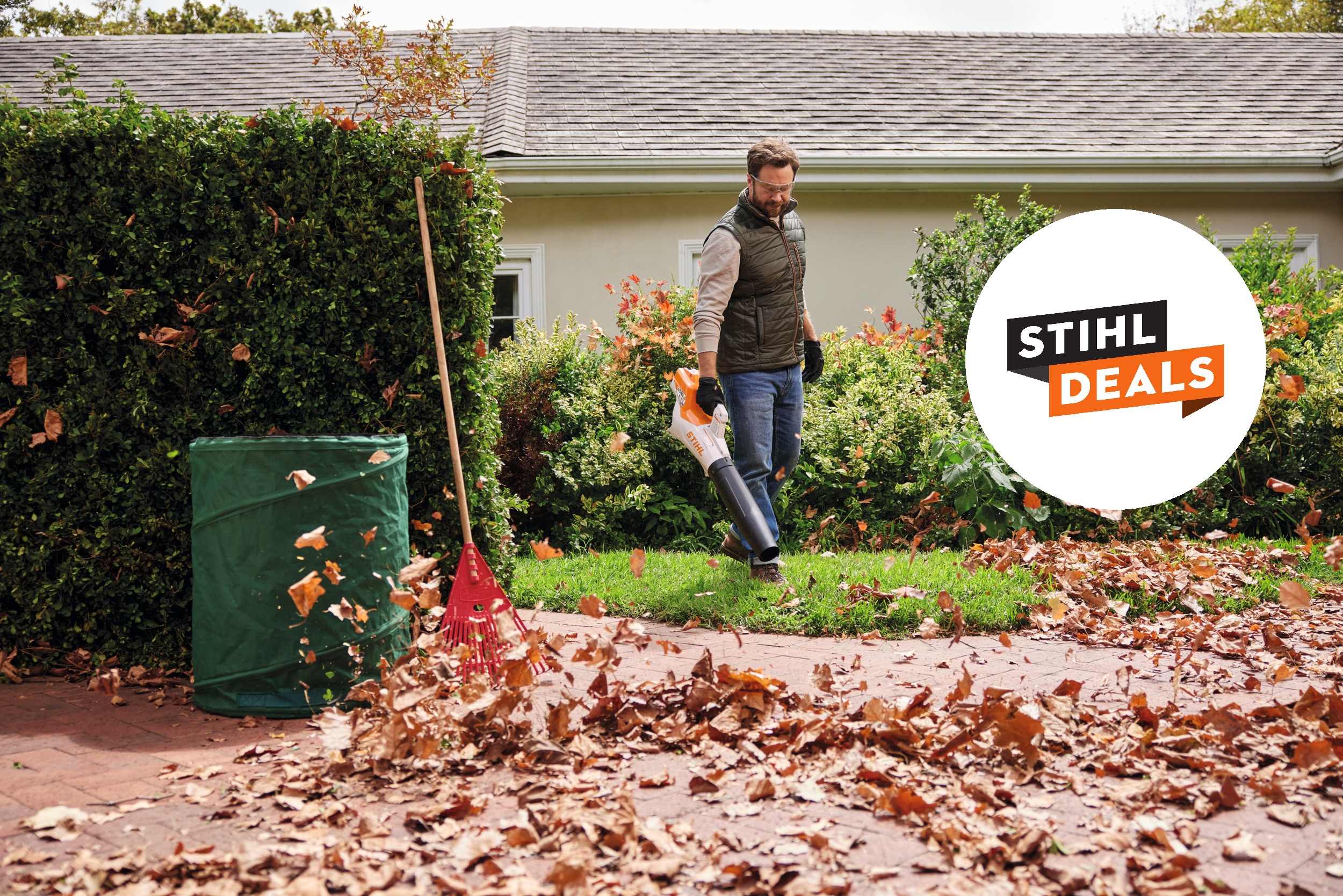 Ein Mann bläst mit BGA 50 Laub und ein STIHL Deals Badge ist zu sehen.