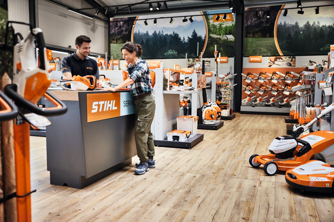 Eine Frau lässt sich durch einen Mann am Service-Schalter im STIHL Fachhandel beraten