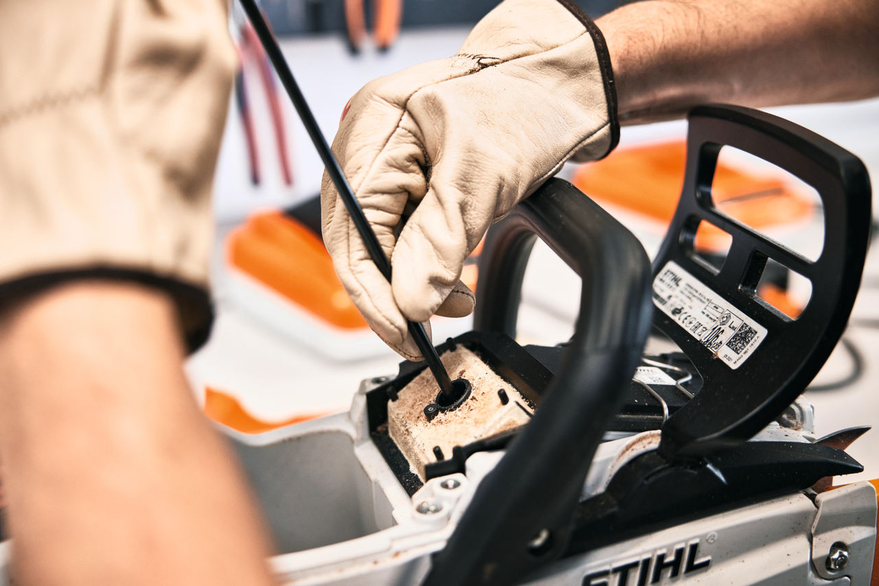STIHL Mitarbeiter oder Fachhändler repariert eine Motorsäge